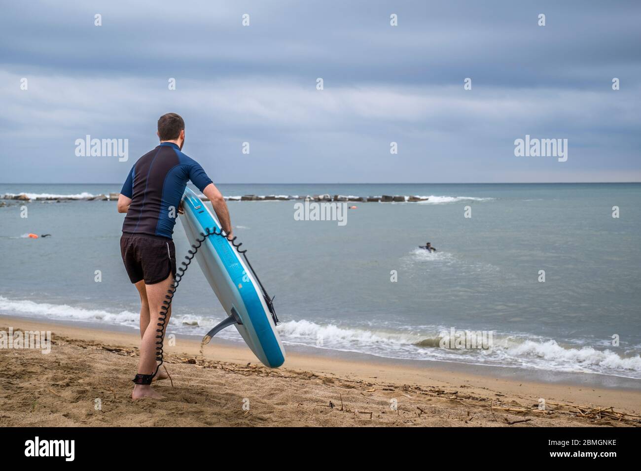 Un surfeur se prépare à entrer dans l'eau pendant les créneaux autorisés pour la pratique du sport en période de pandémie du coronavirus.la phase zéro permet à Barcelone de rouvrir les plages pour le sport individuel réglementé dans les tranches horaires en raison de la contagion de Covid-19. Banque D'Images
