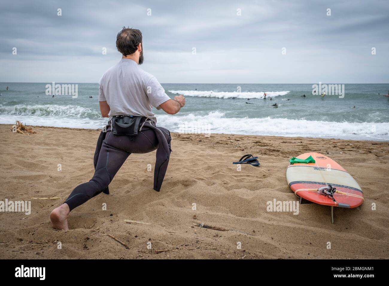 Un surfeur est vu s'étirer pendant les créneaux autorisés pour la pratique du sport dans le cadre de la pandémie du coronavirus.phase zéro permet à Barcelone de rouvrir les plages pour le sport individuel réglementé dans les tranches horaires en raison de la contagion de Covid-19. Banque D'Images