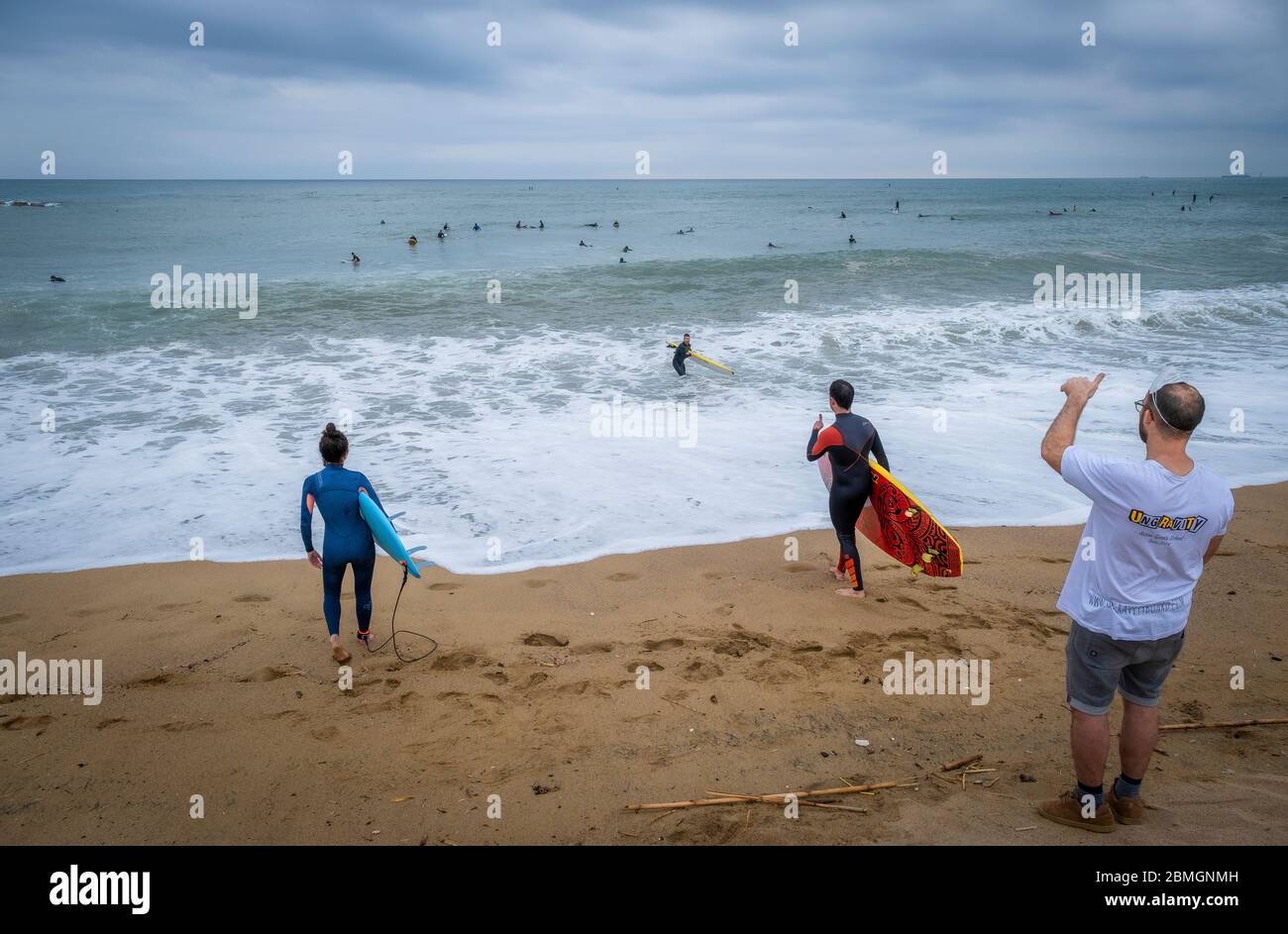 Deux surfeurs se préparent à entrer dans l'eau pendant les créneaux prévus pour la pratique du sport en raison de la pandémie du coronavirus.la phase zéro permet à Barcelone de rouvrir les plages pour le sport individuel réglementé dans les tranches horaires en raison de la contagion de Covid-19. Banque D'Images