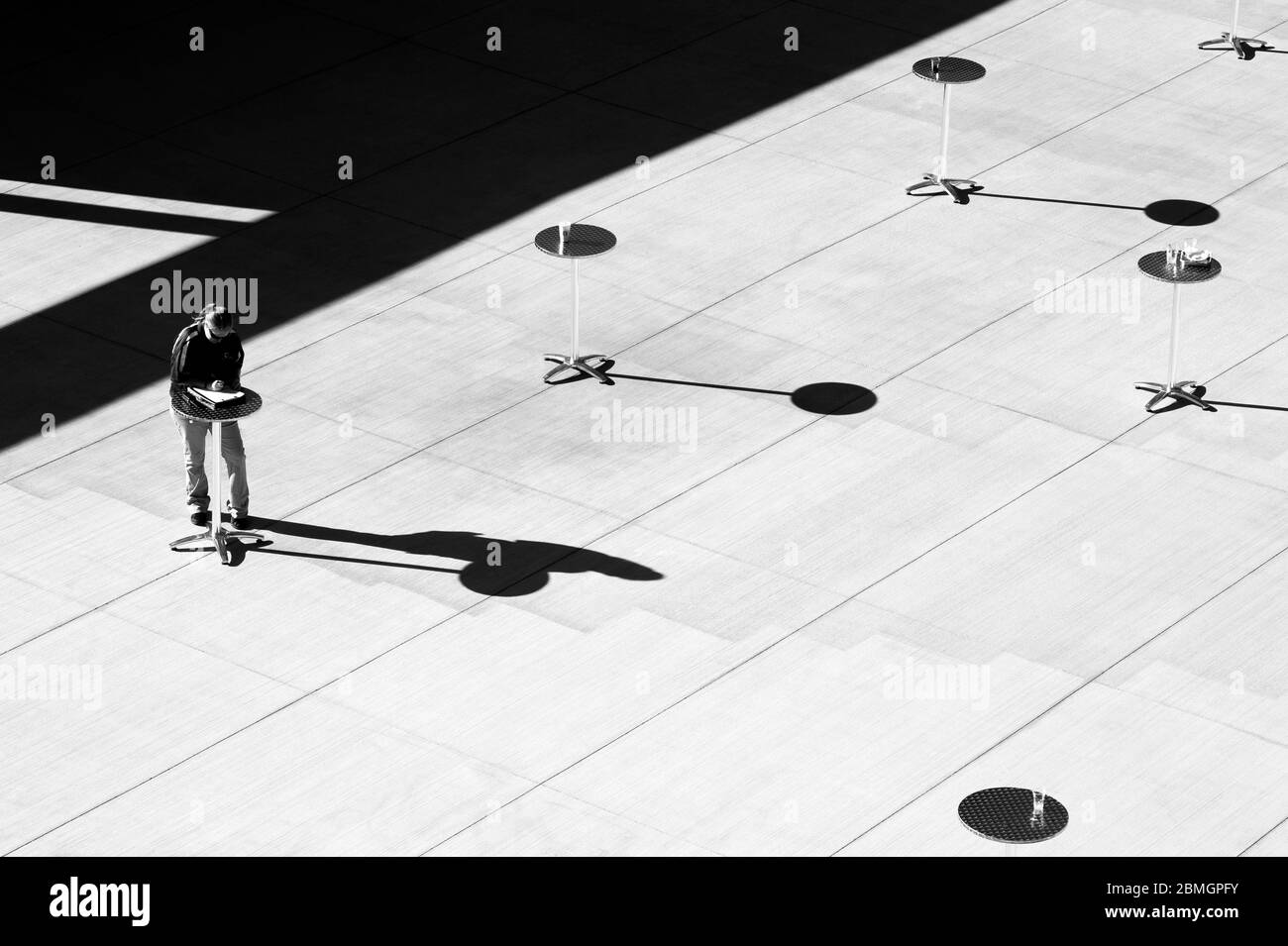 Tables extérieures au soleil avec ombres et notes de femme Banque D'Images