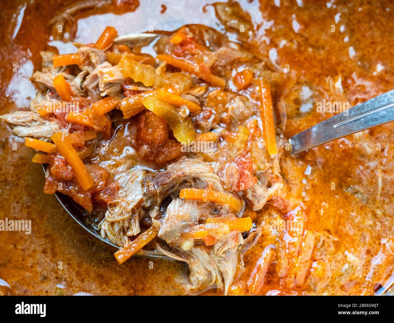La louche ramasse une portion de soupe Oxtail maison dans le stewpot de près Banque D'Images