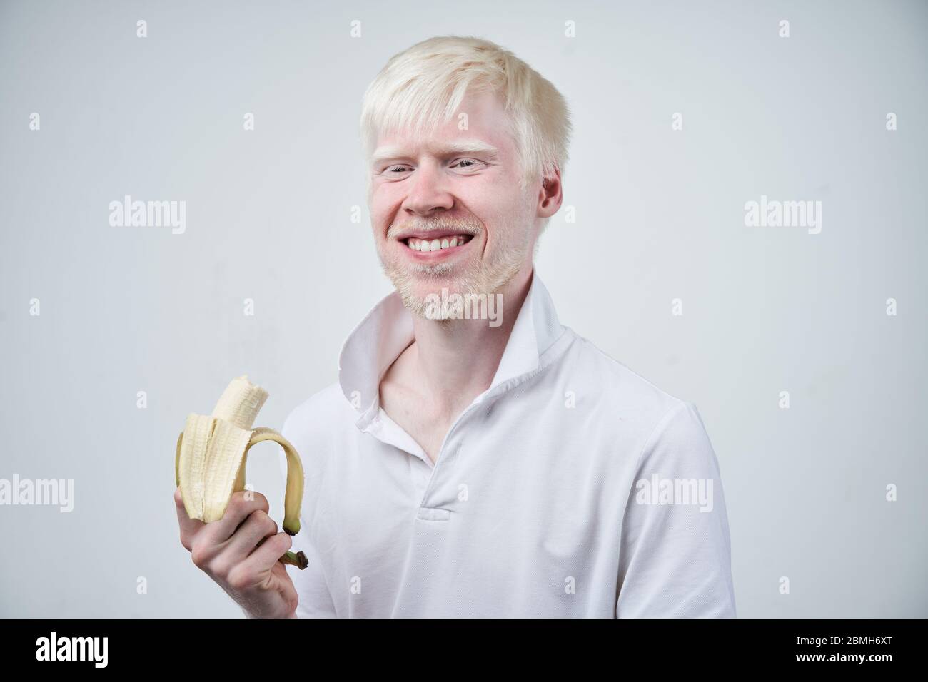 Happy albino homme peau blanche cheveux studio habillé t-shirt isolé fond blanc. Anomalies. Aspect inhabituel. Anomalie de la peau beau Banque D'Images