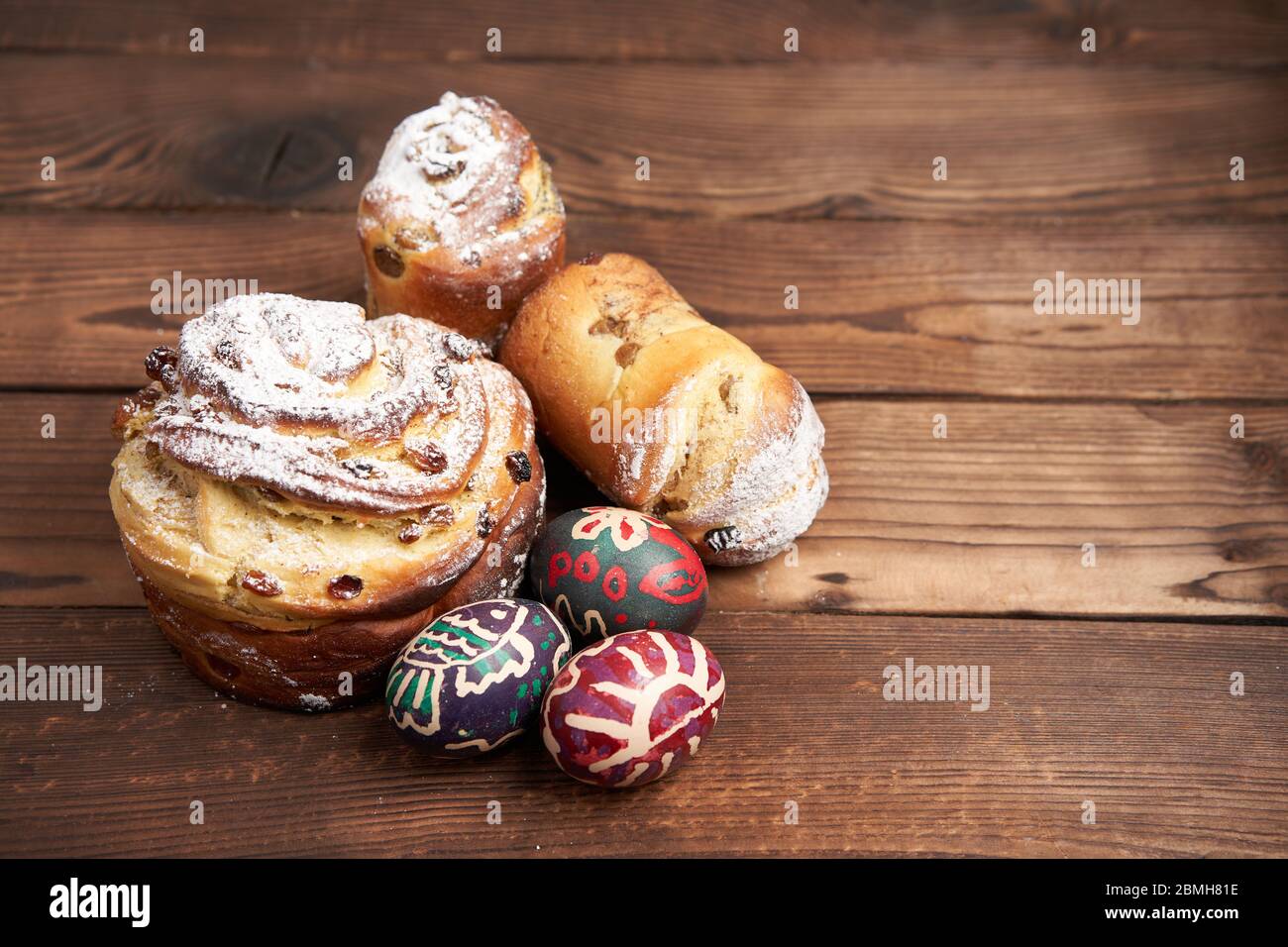 Le traditionnel kraffin à gâteau de pâques se dresse sur une table en bois sur fond sombre. Pain de vacances de printemps avec espace de copie peint oeufs de pâques Banque D'Images