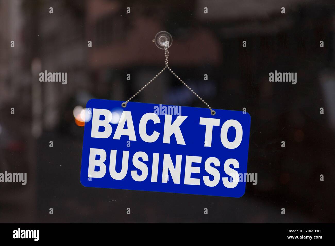 Gros plan sur un panneau bleu ouvert dans la fenêtre d'une boutique affichant le message « Retour à l'entreprise ». Banque D'Images