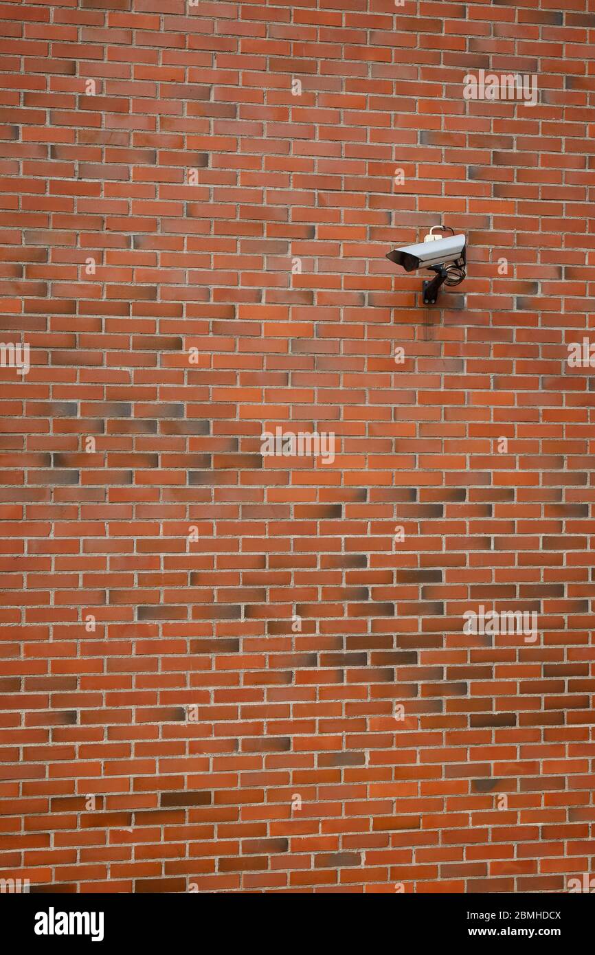 Caméra de vidéosurveillance montée sur un mur en brique rouge. Banque D'Images