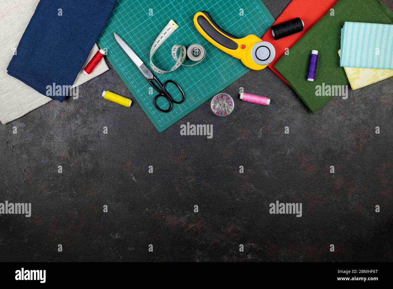 il y a des outils de courtepointes, de broderie et de couture sur la table. couteau patchwork, ciseaux, tapis de coupe doublé, autobloquant, fils, ruban de mesure, coudre Banque D'Images il y a des outils de courtepointes, de broderie et de couture sur la table. couteau patchwork, ciseaux, tapis de coupe doublé, autobloquant, fils, ruban de mesure, coudre Banque D'Images