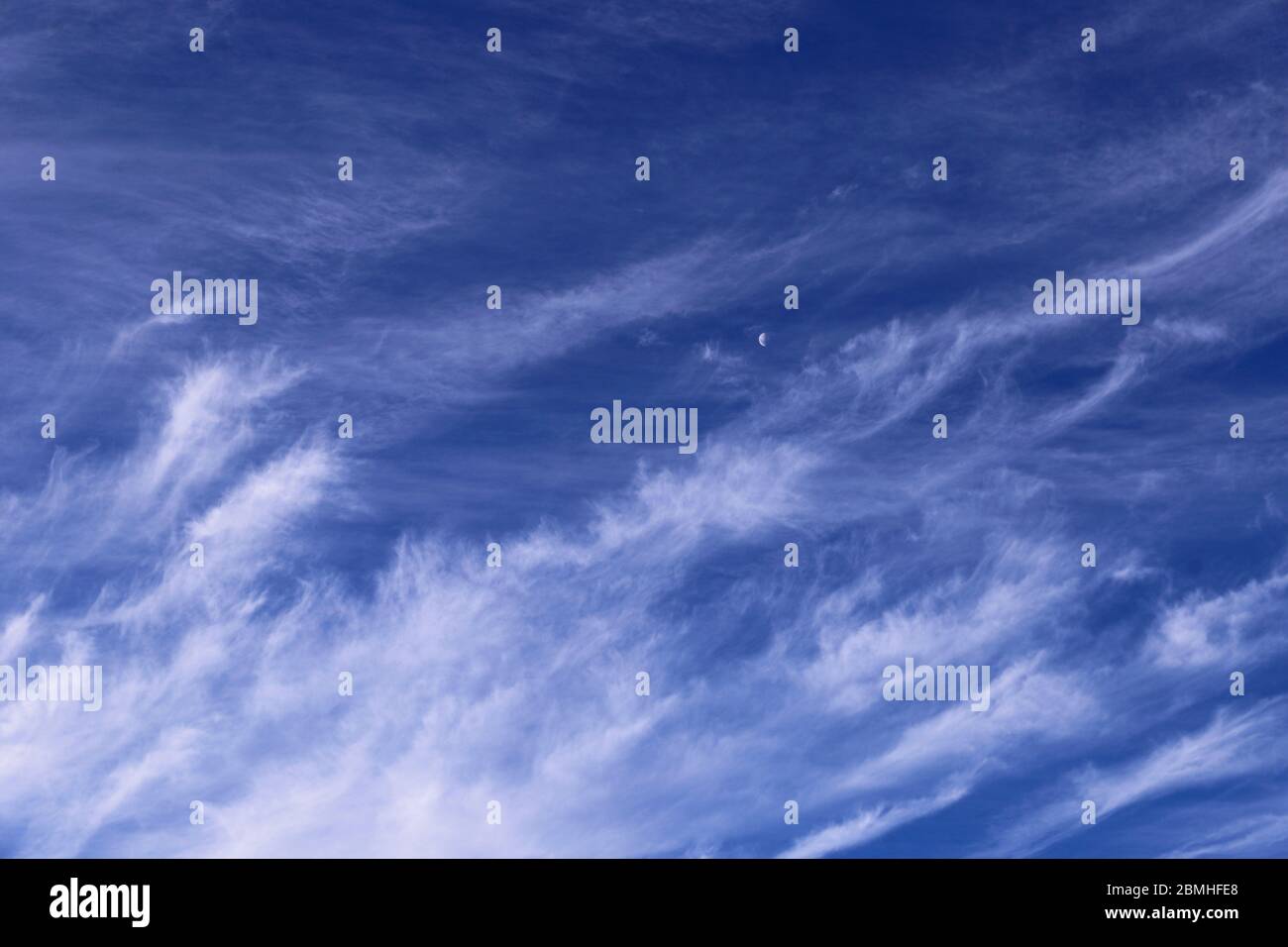nuages blancs de cirrus dans le ciel bleu jour et lune Banque D'Images
