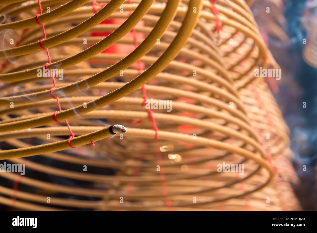 Bâton d'encens beige spiralé suspendu dans un temple bouddhiste Banque D'Images