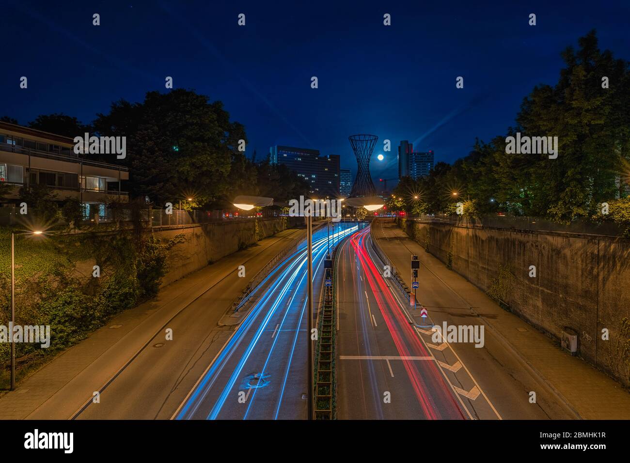 Promenade nocturne avec des sentiers de voitures légers dans le quartier bavarois de Munich par faible lumière. Banque D'Images