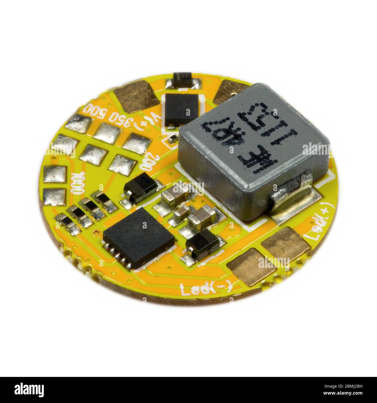 Carte PCB de driver de LED ronde jaune avec bobine d'inductance et composants à montage en surface dans une vue rapprochée Banque D'Images