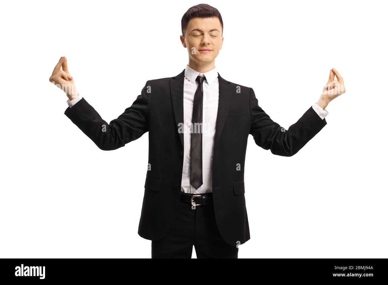 Jeune homme en costume et cravate pratiquant la méditation avec les yeux fermés isolés sur fond blanc Banque D'Images