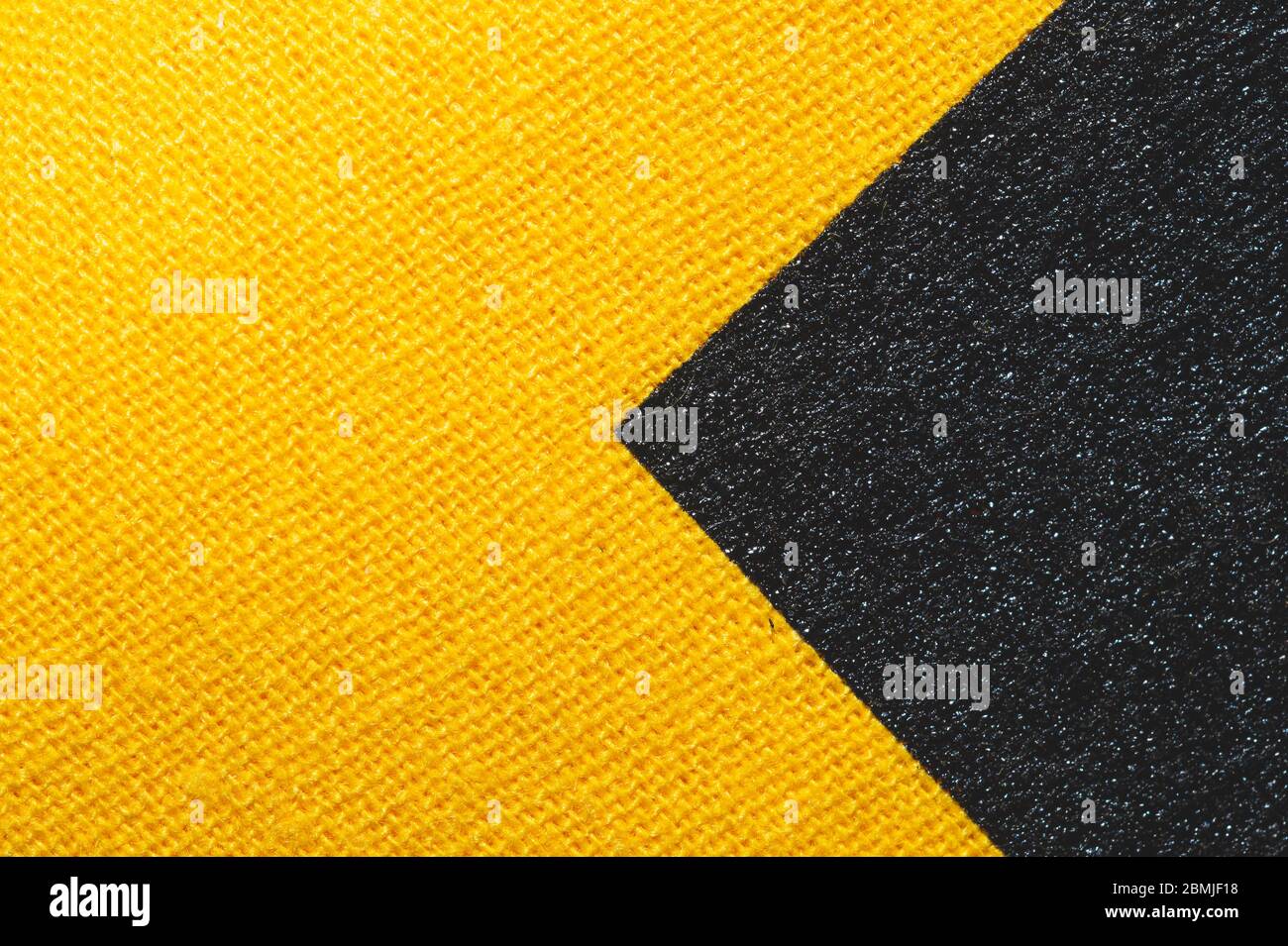 Texture de tissu noir et jaune. Tissu en maille gros plan. Macro de fond tissé Banque D'Images