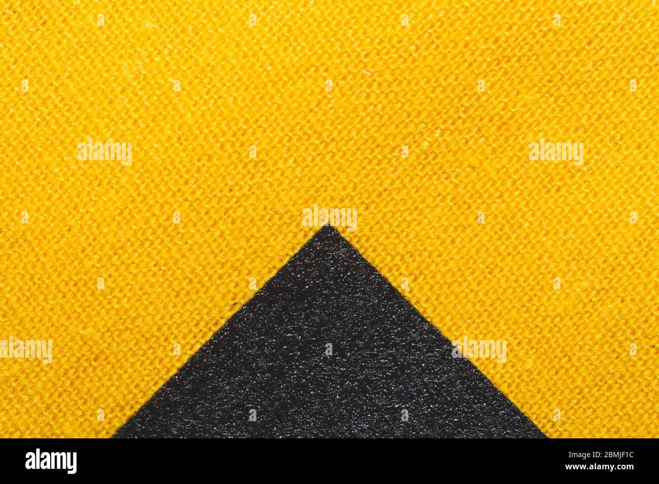 Texture de tissu noir et jaune. Tissu en maille gros plan. Macro de fond tissé Banque D'Images