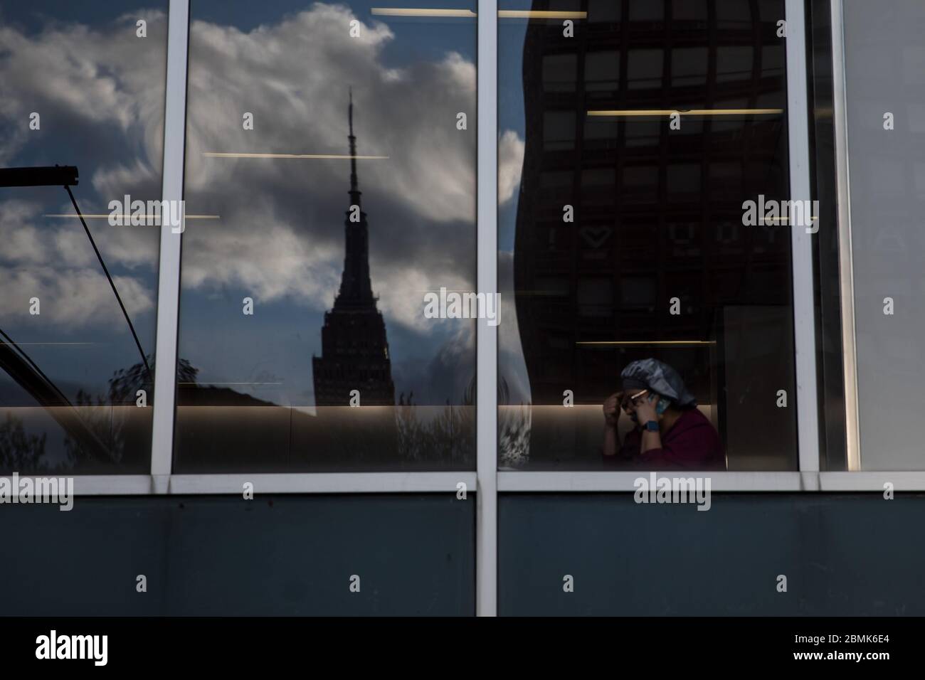 New York, États-Unis. 9 mai 2020. Un professionnel de la santé du NYU Langone Medical Center parle au téléphone alors que l'édifice de l'Empire State se reflète dans une fenêtre au milieu de l'épidémie de COVID-19 à New York, aux États-Unis, le 9 mai 2020. Le nombre de cas de COVID-19 aux États-Unis a atteint 1,300,079 à 3 h 32 (1932 GMT) samedi, selon le Centre for Systems Science and Engineering (CSSE) de l'Université Johns Hopkins. Pendant ce temps, le nombre de décès dus à la maladie dans le pays a atteint 78,320. Crédit: Michael Nagle/Xinhua/Alay Live News Banque D'Images