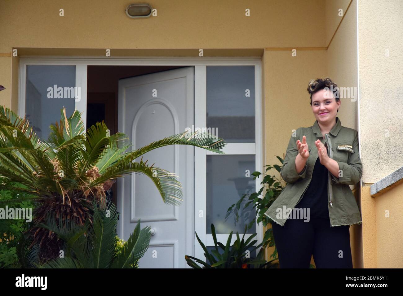 Vendrell, Espagne. 25 avril 2020. Une femme applaudit ses voisins sur la terrasse de sa maison pour les encourager pendant la détention dans un contexte de crise du coronavirus.les résidents du quartier de Mas d'en Gual se font entendre et applaudissent à 8 heures pour encourager leurs voisins pendant la détention dans un contexte de crise du coronavirus. Cette fois-ci, ils ont choisi le thème de la série télévisée The Love Boat et les personnages de Peter Pan, qui célèbrent le début de la phase 1. Crédit : Ramon Costa/SOPA Images/ZUMA Wire/Alamy Live News Banque D'Images