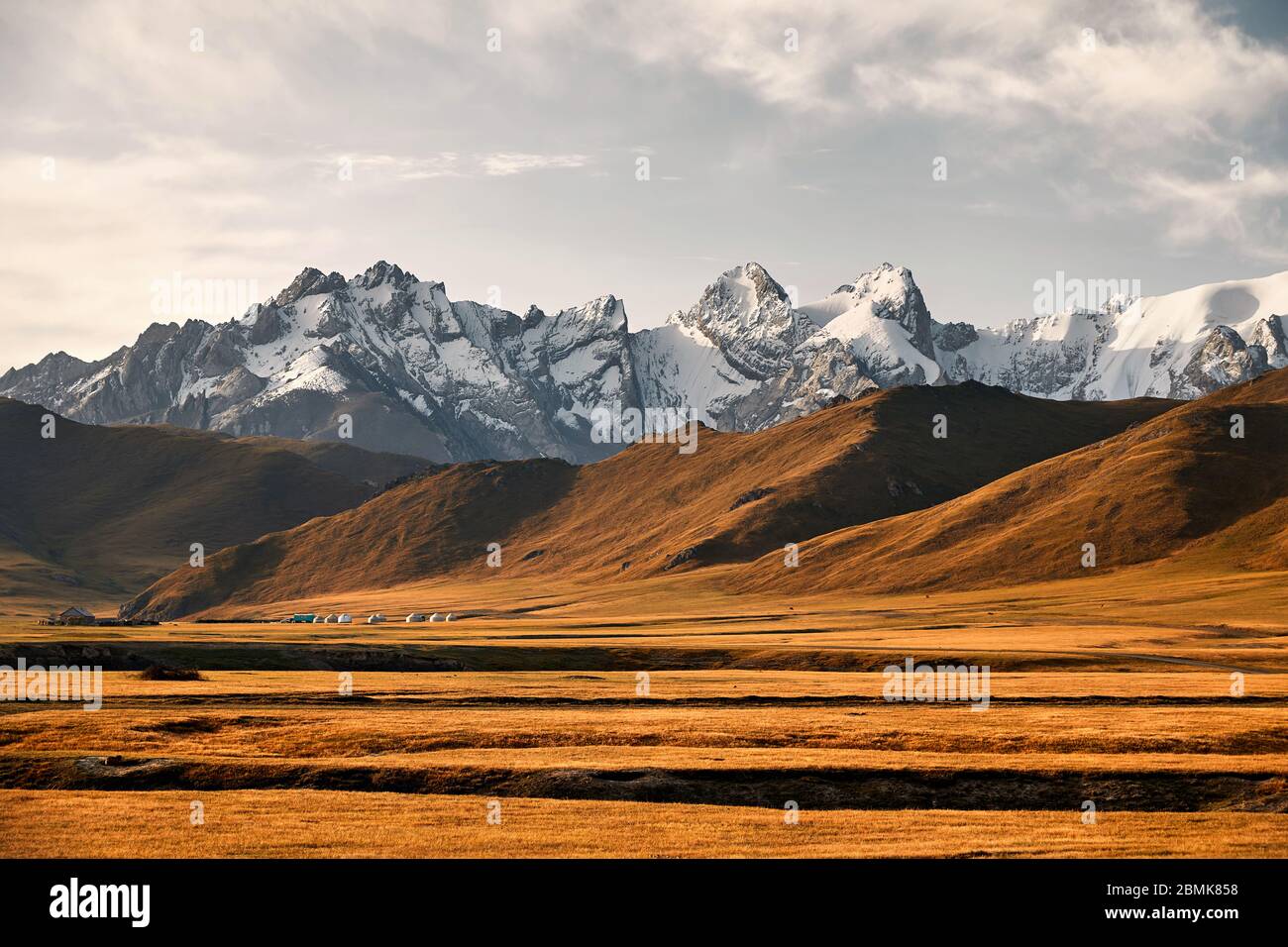 De beaux paysages de montagnes aux sommets enneigés et camp de yourte dans la vallée près de Kel Suu Lake dans la région de Naryn, Kirghizistan Banque D'Images