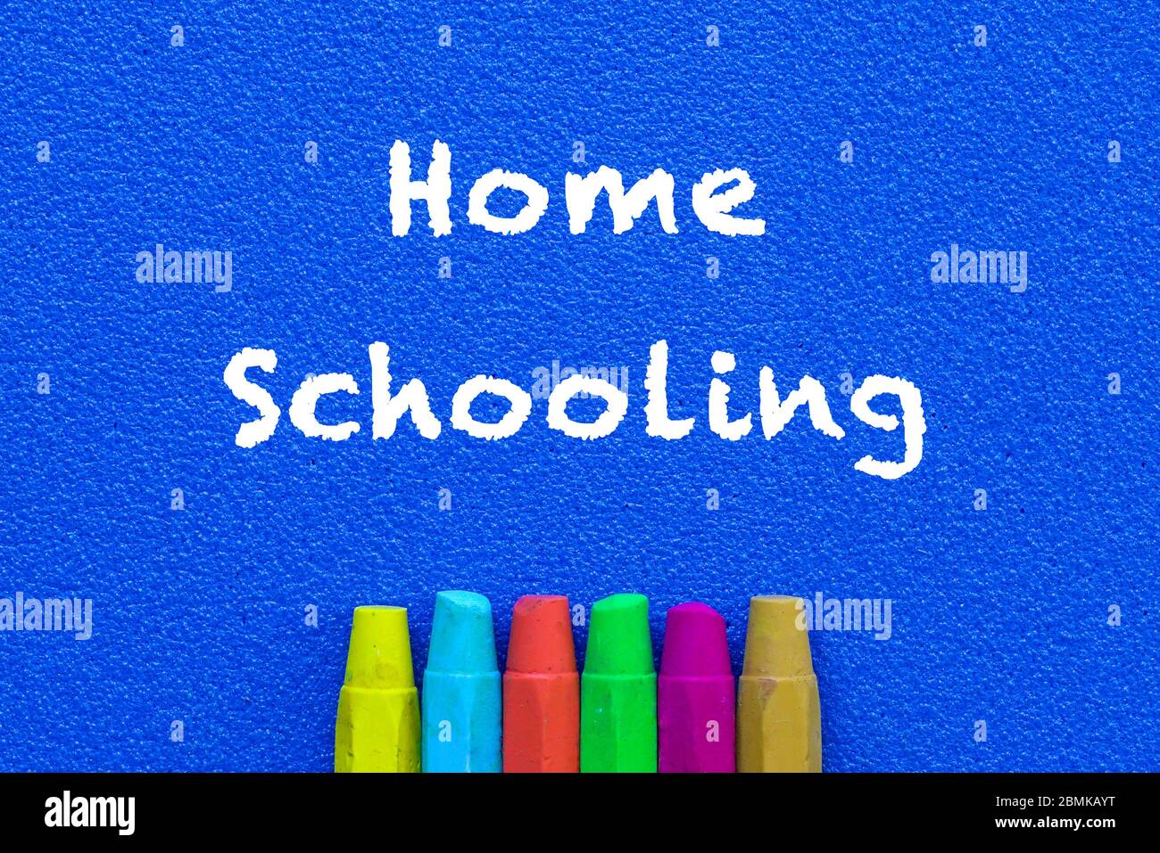 Homeschooling. Mots ou texte tapé sur tableau bleu. Crayons multicolores. Vue de dessus. Concept d'éducation précoce. Banque D'Images