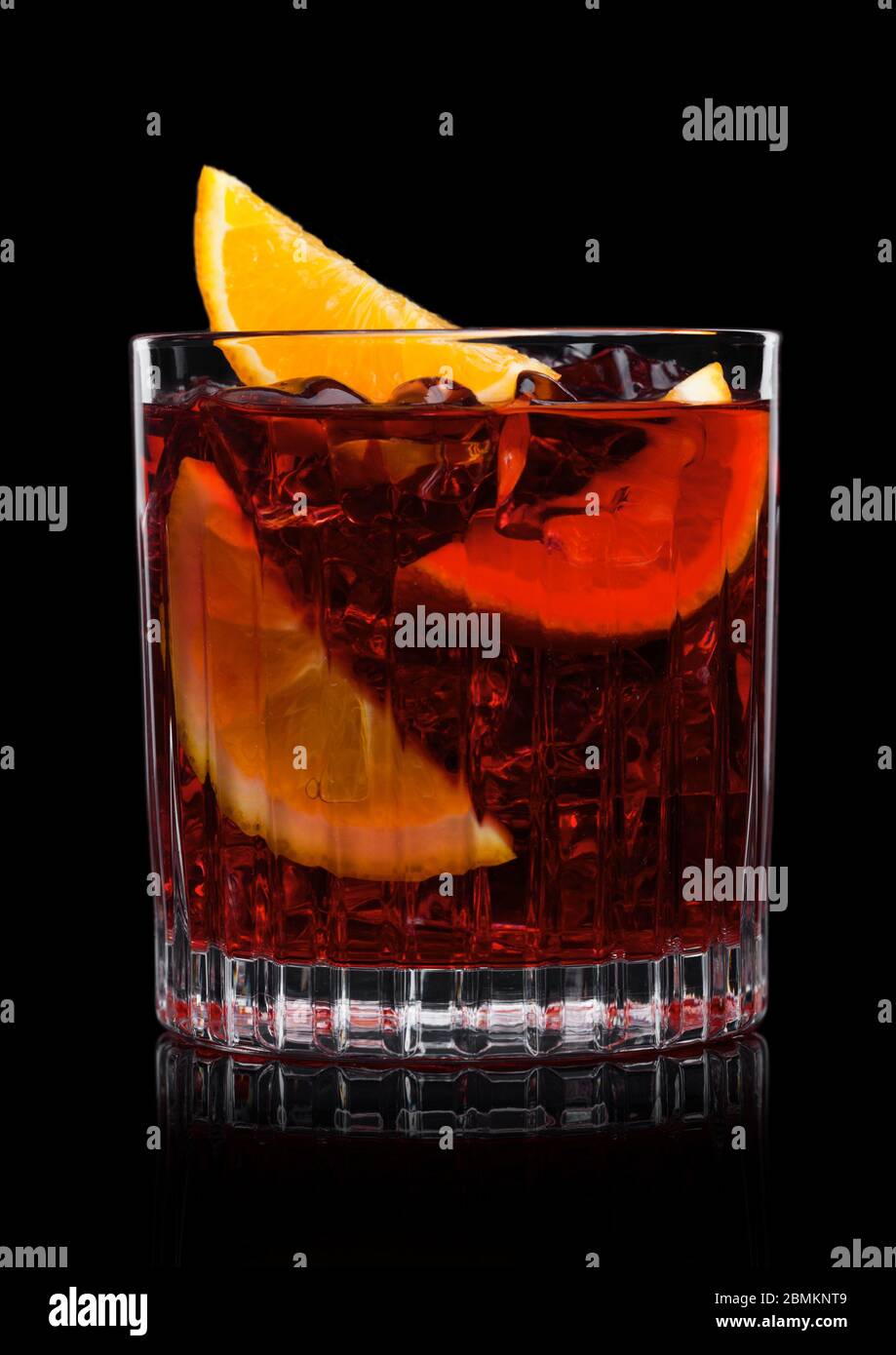 Negroni cocktail en verre cristal avec glaçons et tranches d'orange sur  fond noir Photo Stock - Alamy