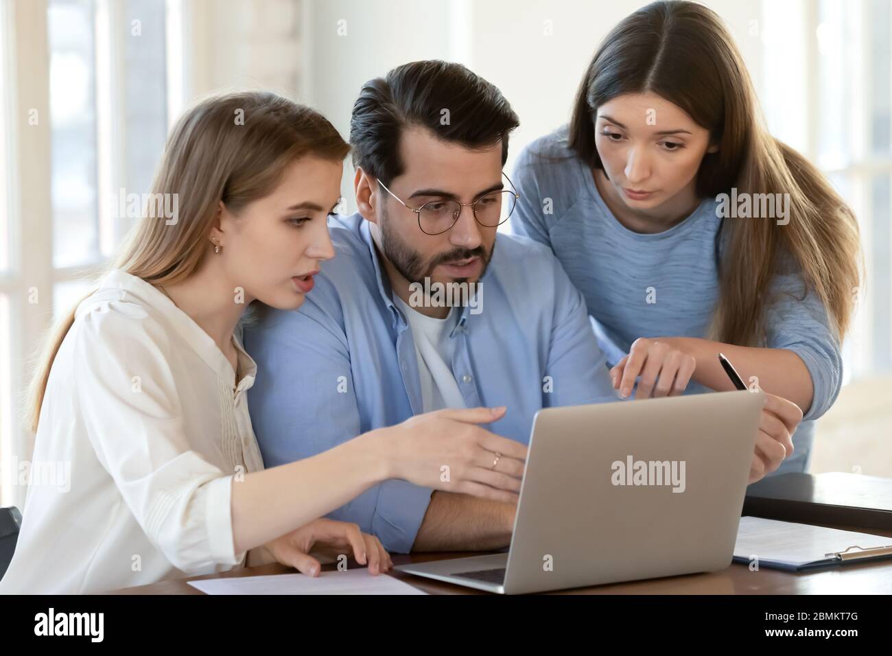 Divers collègues font un brainstorming sur un ordinateur portable Banque D'Images