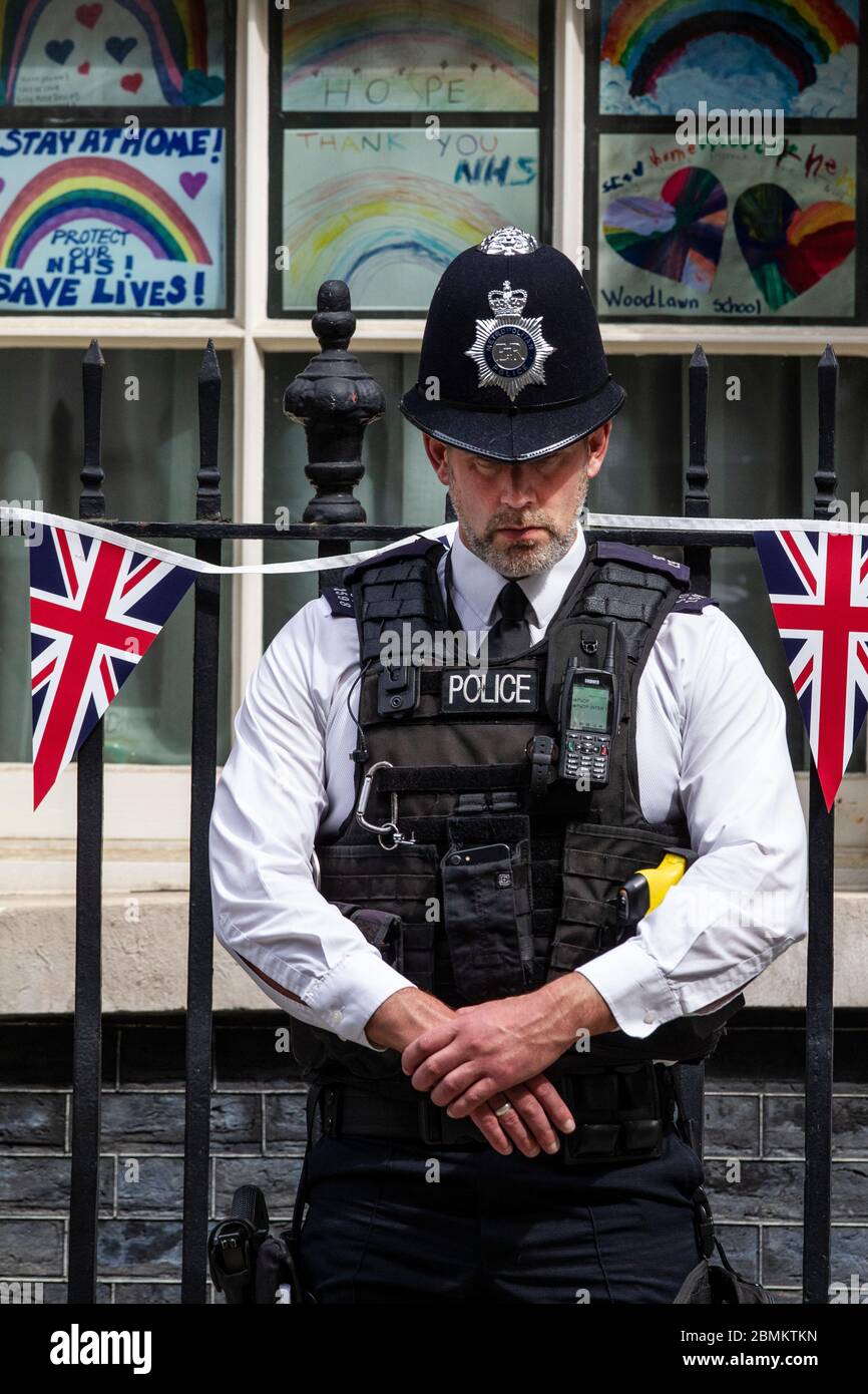 Le policier met devant la rue no 10 Downing Street observe le silence de deux minutes à 11h00 le jour du 75e anniversaire du Ve, Whitehall, Londres, Royaume-Uni Banque D'Images