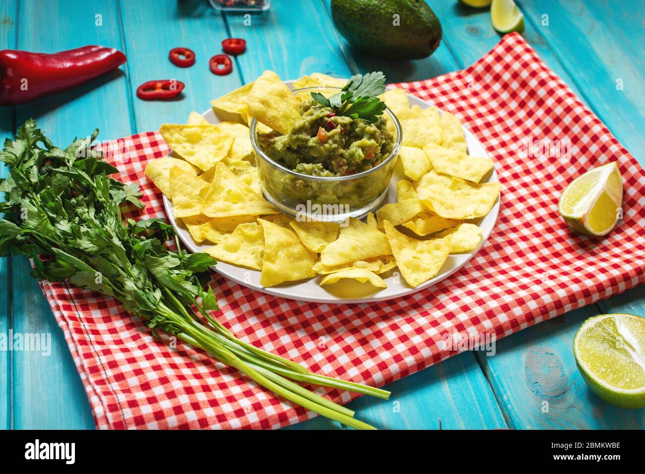 Nachos. Croustilles tortilla avec guacamole sur fond bleu en bois. Banque D'Images