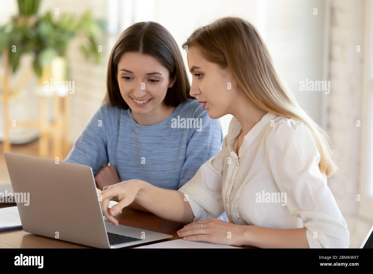 Les employés souriants font un brainstorming pour travailler ensemble sur un ordinateur portable Banque D'Images