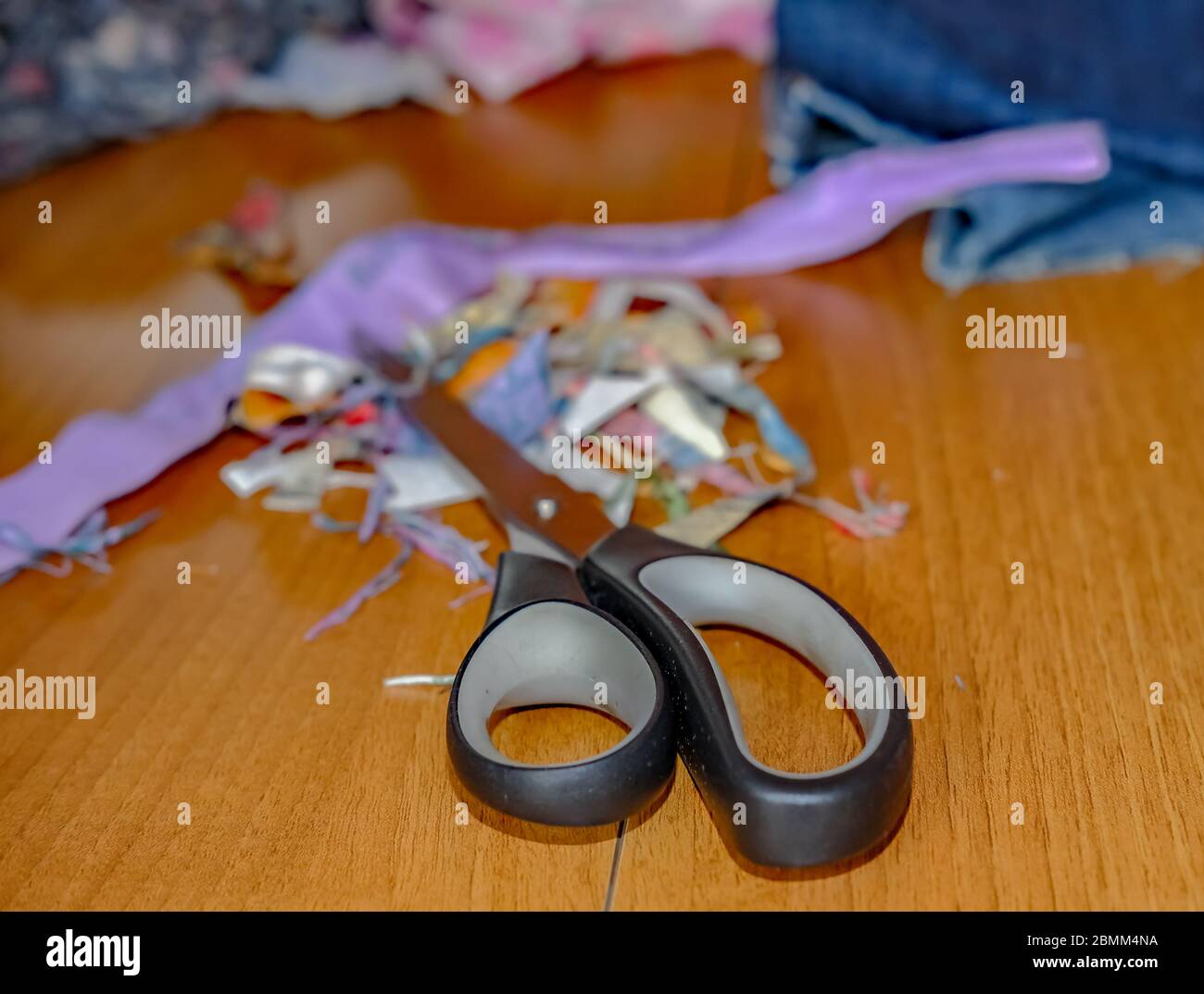 29 l'artisanat à la maison. Gros plan et focus sélectif d'une paire de ciseaux et de tissu de fabrication, en douceur, sur une table en bois pendant un projet de couture Banque D'Images