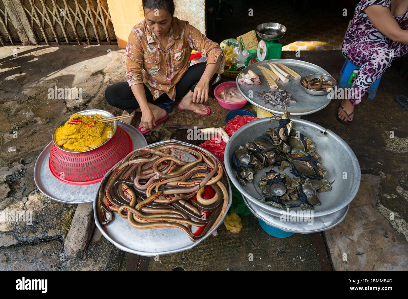 Ho Chi Minh, Vientam - 25 août 2017 : femme vendant des fruits de mer frais, y compris des serpents de mer et des crabes, sur le marché de la nourriture fraîche. Cuisine vietnamienne de rue Banque D'Images