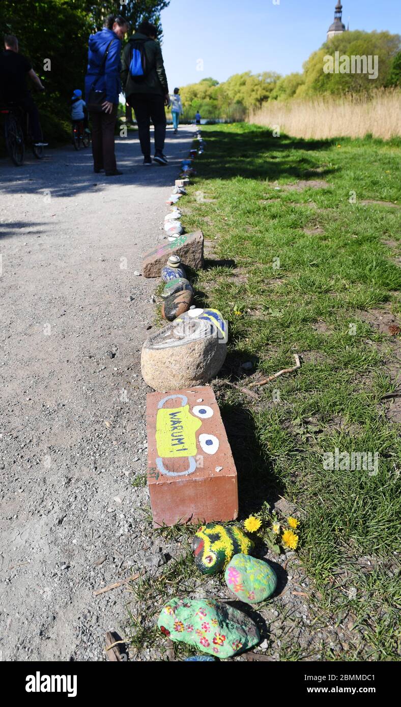 Stralsund, Allemagne. 10 mai 2020. Des pierres peintes en couleurs se trouvent le long d'un sentier de randonnée autour du Frankenteich. Avec des milliers de pierres peintes en couleurs, les gens de Stralsund veulent donner espoir dans la crise de Corona. Le serpent de pierre autour du Frankenteich à Stralsund a grandi à plusieurs centaines de mètres depuis le début du mois d'avril. Des pierres peintes en couleurs sont également mises en place à d'autres endroits dans Mecklembourg-Poméranie occidentale pour le moment. Credit: Stefan Sauer/dpa-Zentralbild/dpa/Alay Live News Banque D'Images