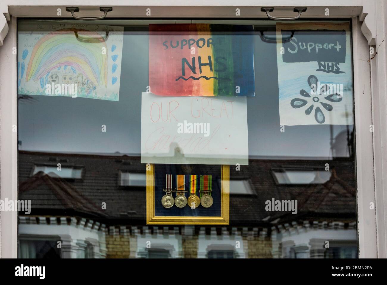 Londres, Royaume-Uni. 10 mai 2020. Médailles d'un grand grand grand-père, pour la journée du VE, avec Rainbow et d'autres messages de soutien au NHS dans une fenêtre de maison. Le jour de l'annonce "grande" des gouvernements sur l'assouplissement éventuel des restrictions. Le « verrouillage » se poursuit pour l'épidémie du coronavirus (Covid 19) à Londres. Crédit : Guy Bell/Alay Live News Banque D'Images