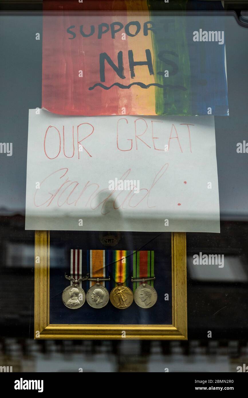 Londres, Royaume-Uni. 10 mai 2020. Médailles d'un grand grand grand-père, pour la journée du VE, avec Rainbow et d'autres messages de soutien au NHS dans une fenêtre de maison. Le jour de l'annonce "grande" des gouvernements sur l'assouplissement éventuel des restrictions. Le « verrouillage » se poursuit pour l'épidémie du coronavirus (Covid 19) à Londres. Crédit : Guy Bell/Alay Live News Banque D'Images