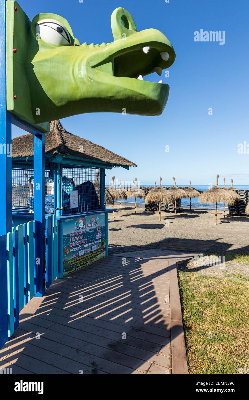 Un crocodile vert de dessin animé tête à une aire de jeux pour enfants pendant le covid 19 verrouillage dans la station touristique de Costa Adeje, Tenerife, île des Canaries Banque D'Images