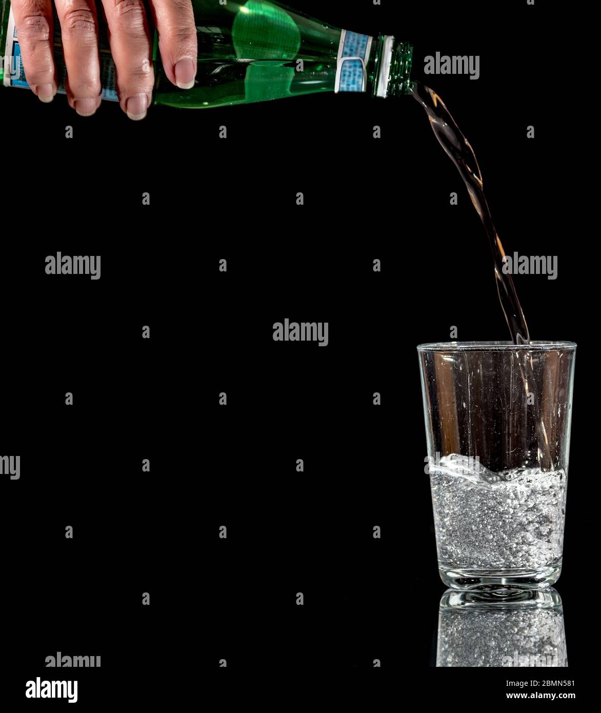 Verser de l'eau minérale dans un verre. Banque D'Images