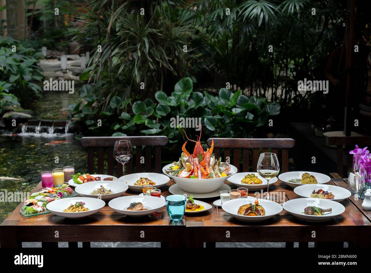 Vue latérale variété de spécialités internationales dans le jardin du restaurant de crevettes de homard steak boeuf agneau pâtes spaghetti risotto riz sushi sashimi a Banque D'Images