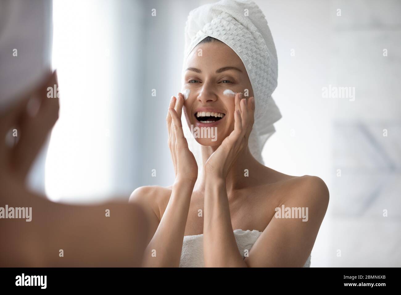 Femme toucher visage appliquer soin de la peau utilise crème hydratante Banque D'Images