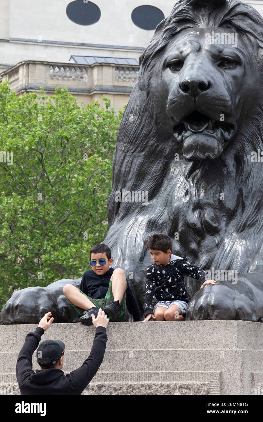 Londres, Royaume-Uni : une famille à Trafalgar Square s'arrête pour prendre des photos avec l'une des statues géantes du lion et parvient à suivre des conseils de social-distance. Le Premier ministre Boris Johnson est prêt à annoncer un certain assouplissement des règles. Anna Watson/Alay Live News Banque D'Images