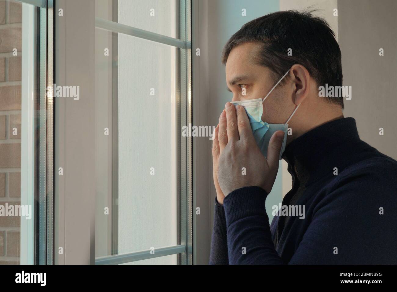 Le jeune homme met un masque médical et sort Banque D'Images