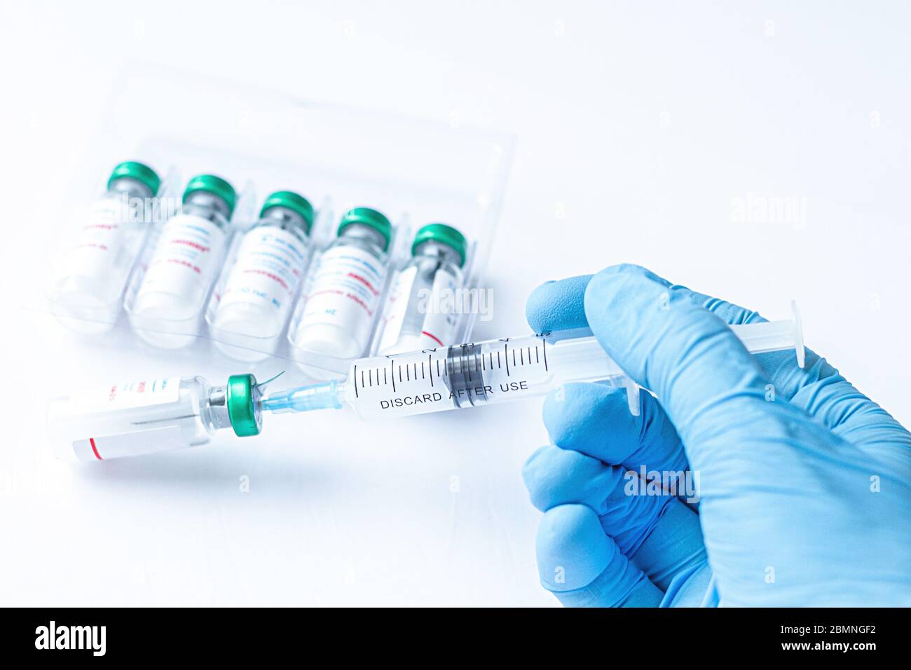 La main du médecin dans un gant médical tient une seringue avec le coronavirus, le COVID-19,nCoV 2019 et le vaccin contre la grippe. Médecine infectieuse concept. Banque D'Images