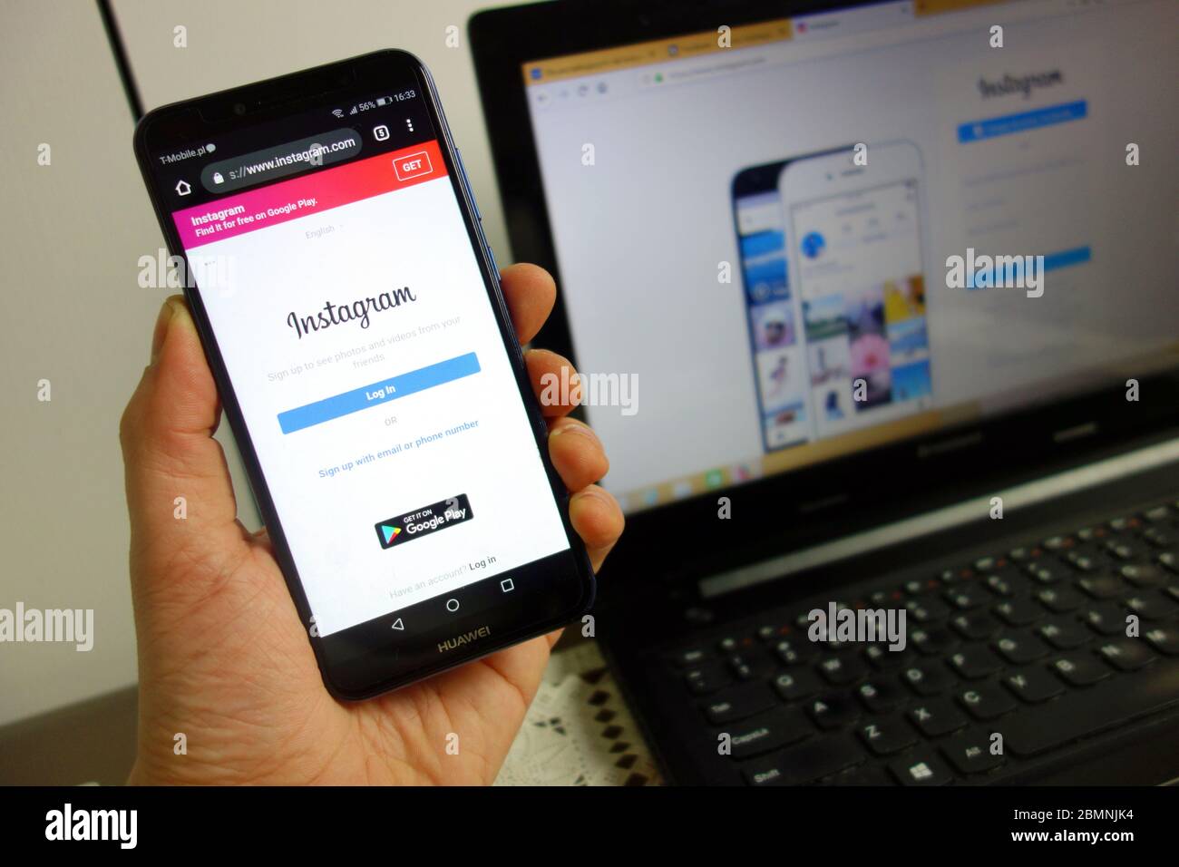 Site Instagram sur le smartphone Huawei avec ordinateur portable en arrière-plan. Médias sociaux utilisant le concept Banque D'Images