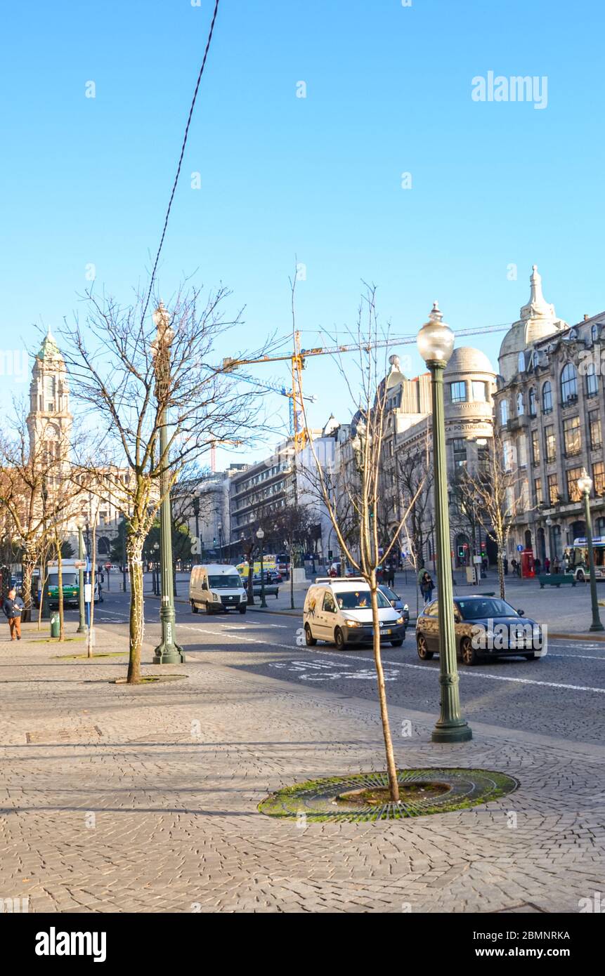 Porto, Portugal - 10 janvier 2020 : rue iin la vieille ville historique de la ville portugaise. Route avec voitures, les gens dans la rue. Photo verticale. Banque D'Images