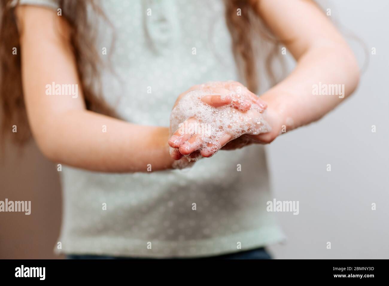 Mains d'enfants dans de la mousse savonneuse. Concept d'hygiène prévenir la propagation des germes et des bactéries et éviter les infections du virus corona Banque D'Images