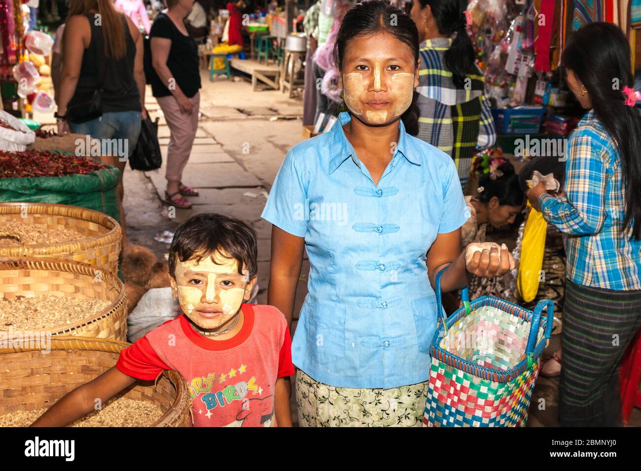 Myanmar - octobre 29 2013; femme et son fils avec visages daubed avec thanaka marchant à travers les marchés. Banque D'Images