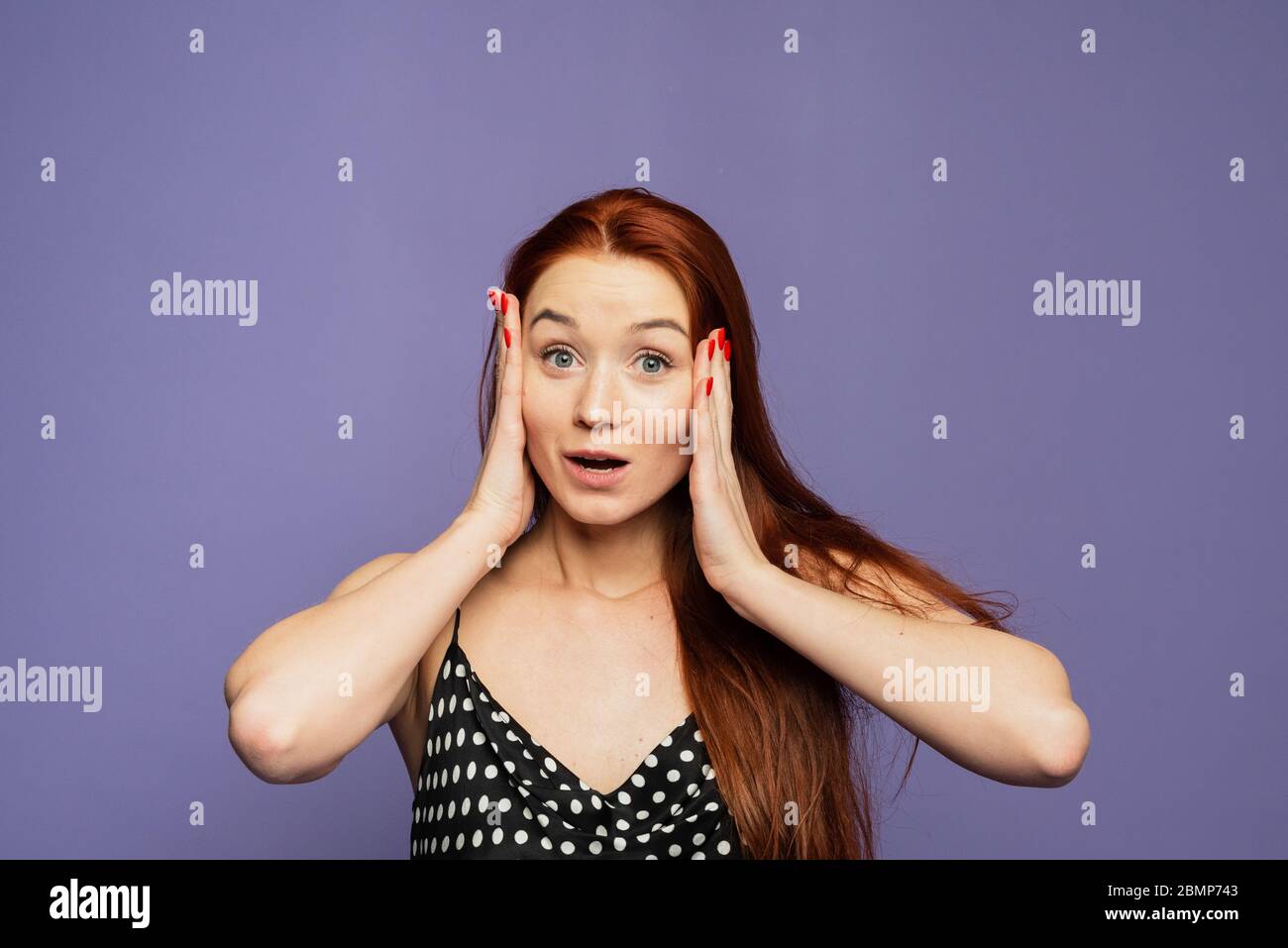 Une nouvelle inattendue et une émotion vive, une femme sur un fond violet a appris quelque chose d'inattendu et agréable, elle a été surprise, enchantée et joyfu Banque D'Images