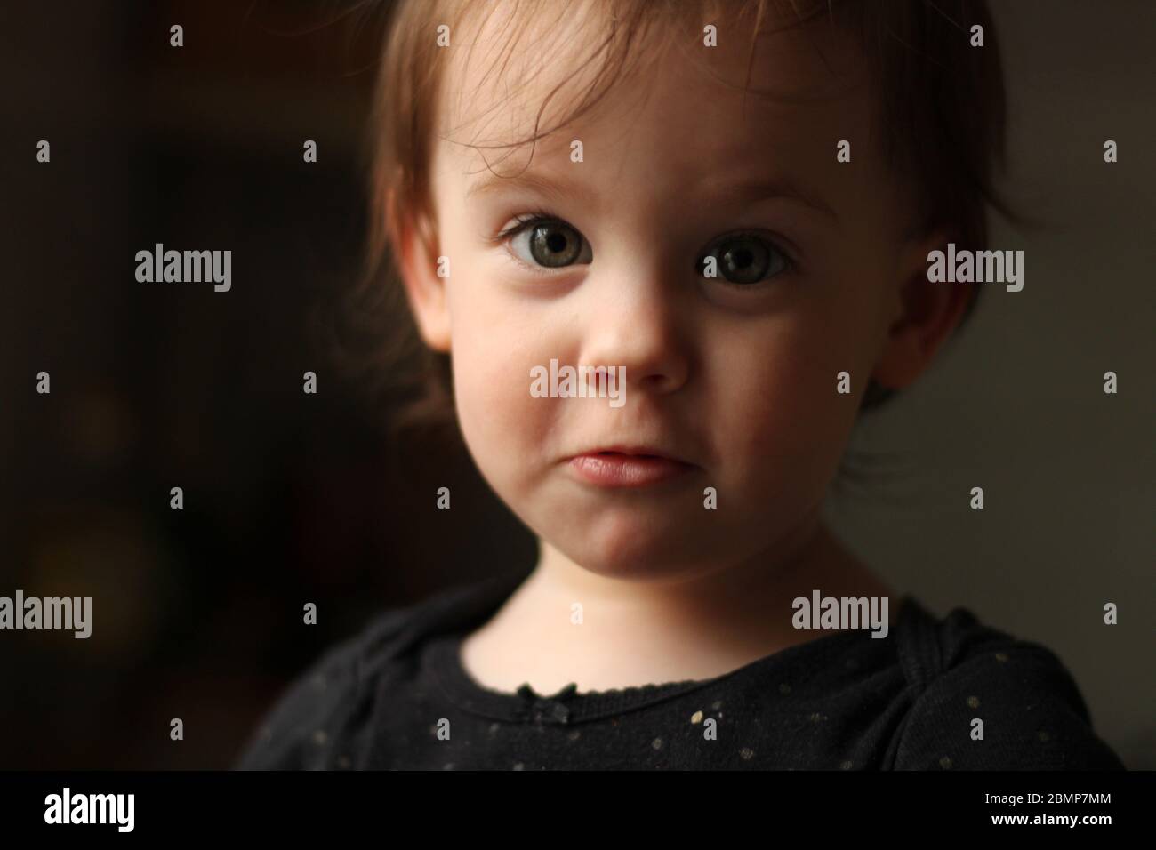 Portrait en gros plan d'un bébé blanc mignon avec un visage sale dans un environnement doux et flou Banque D'Images