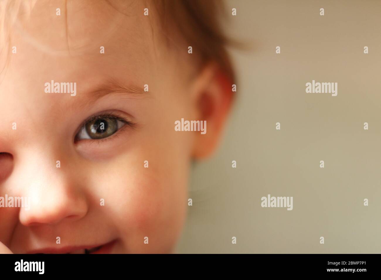 Portrait en gros plan d'un bébé blanc mignon avec un visage sale dans un environnement doux et flou Banque D'Images