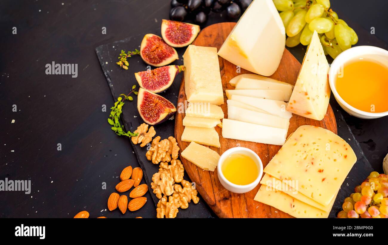 Assiette de fromage servi avec des raisins, confiture, figues, les craquelins et les écrous Banque D'Images