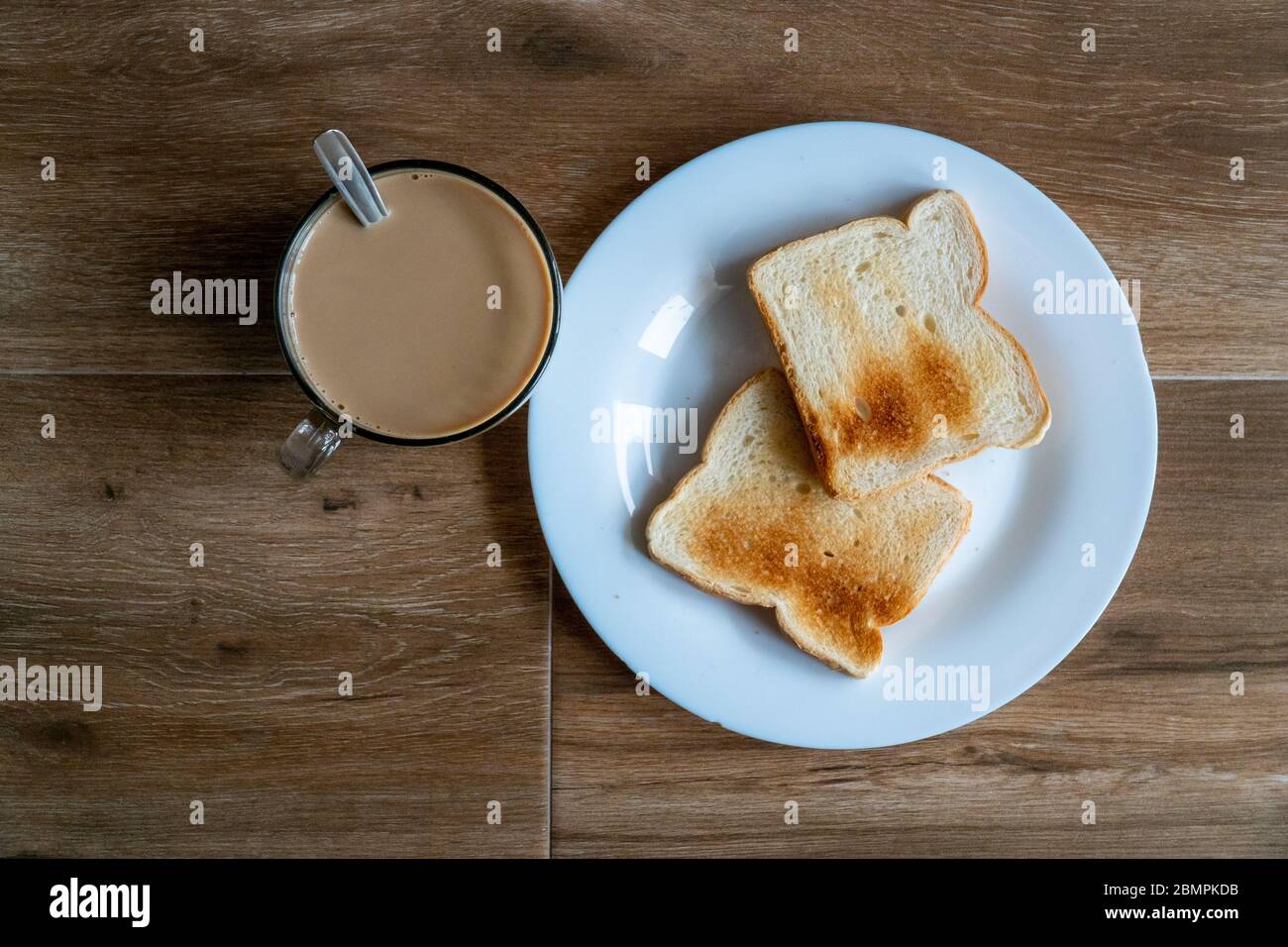 Tasse de café avec lait et deux tranches de pain croque-monsieur grillé sur une assiette blanche. Petit déjeuner sain avec café. Vue de dessus. Espace libre pour le texte. Banque D'Images