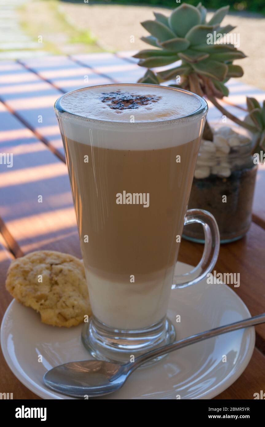 Boisson au café dans un grand verre transparent. Café blanc plat ou latte  servi à l'extérieur dans un verre avec biscuit, biscuit sur un côté. Set  café-restaurant Hipster Photo Stock - Alamy