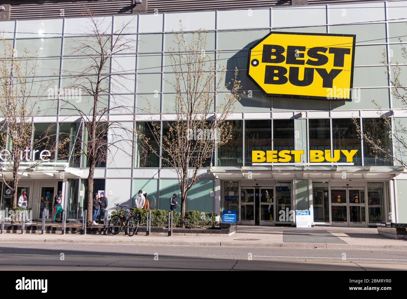 Les clients qui pratiquent la distanciation sociale en ligne à l'extérieur d'un magasin Best Buy au centre-ville de Toronto. Banque D'Images