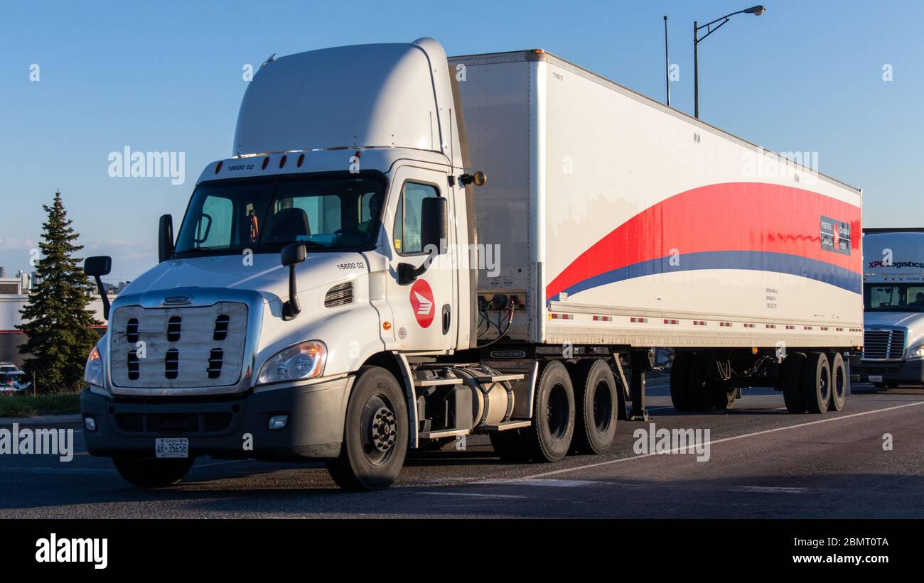 Un camion et une remorque de postes Canada sur une rampe de sortie d’autoroute près du Centre de distribution de postes du Canada, un après-midi ensoleillé. Banque D'Images